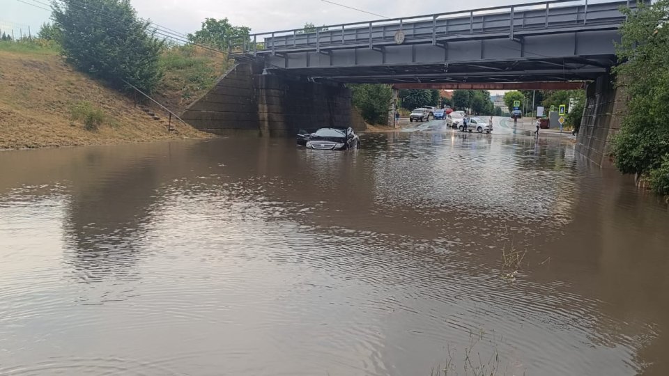 Inundații la Făgăraș. Autoturism blocat sub podul de pe strada 13 Decembrie